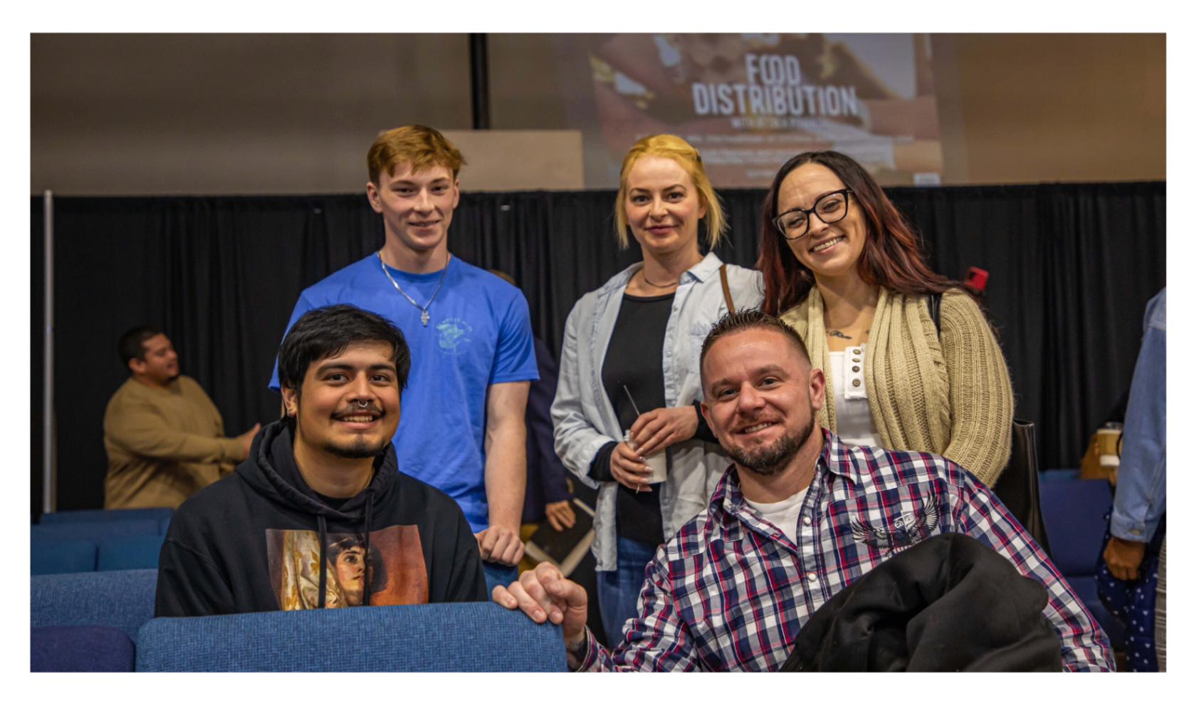 Adults and students smiling together before or after a church event