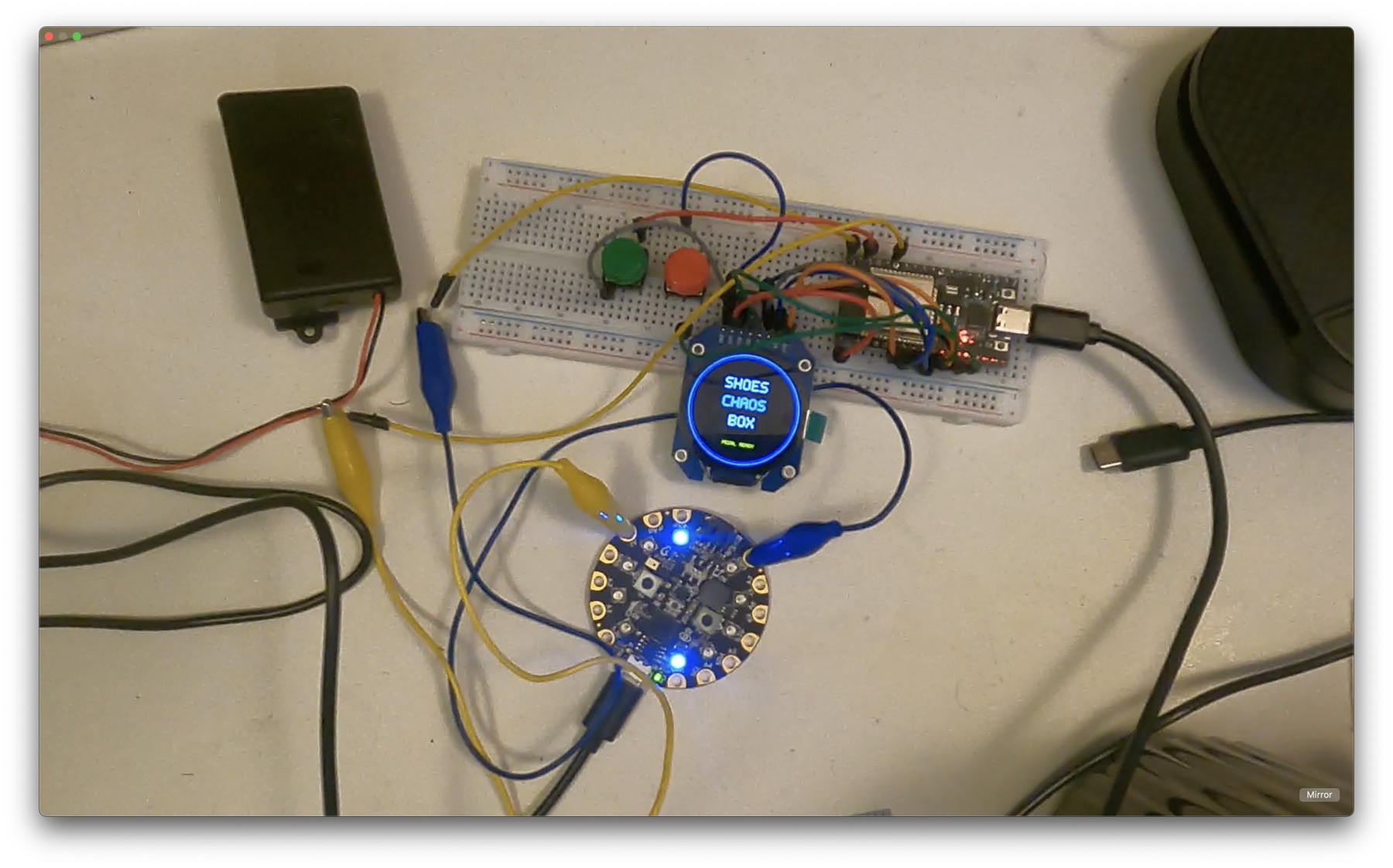 Early electronics bench test with breadboard, ESP32, round blue display, buttons, and Circuit Playground Express board